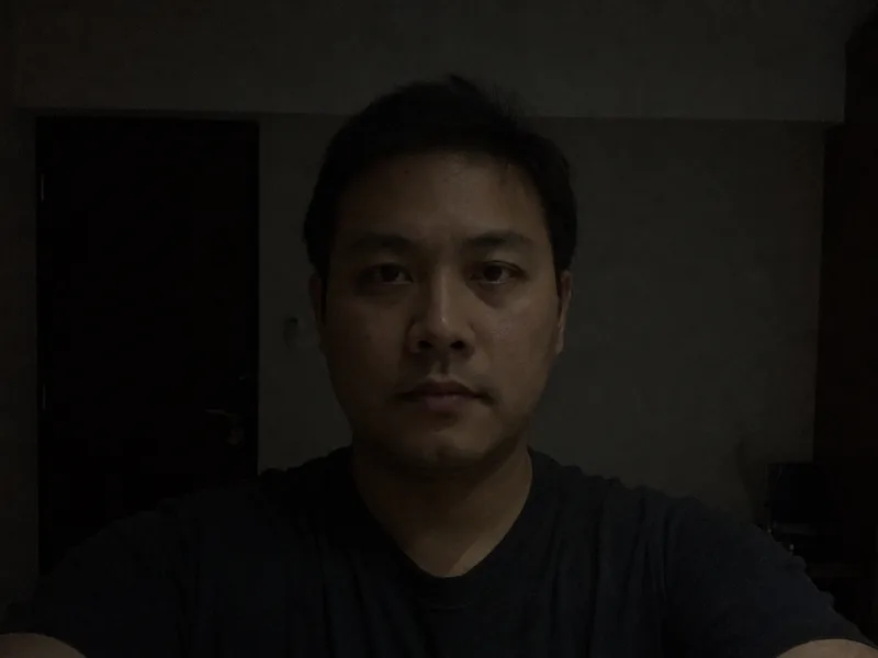 A dark, underexposed selfie with heavy shadows — not allowed